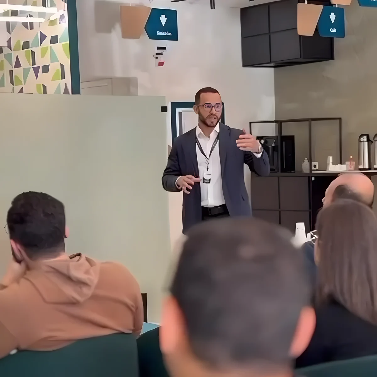 Vitor Rodrigues Dias, de blazer, falando em pé na palestra sobre a Reforma Tributária.
